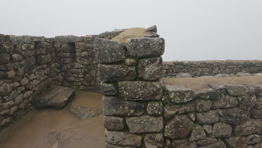 Slow motion video of Inca stone structures inside Machu Picchu, showing ancient walls and architecture in Peru
