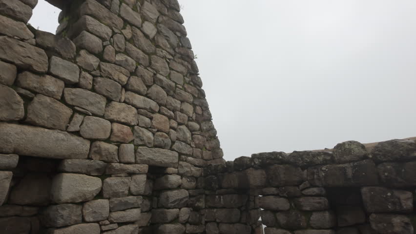 Slow motion video of Inca stone structures inside Machu Picchu, showing ancient walls and architecture in Peru