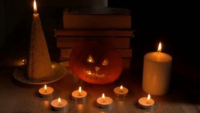 Cozy Halloween scene featuring glowing candles, a carved pumpkin, and stacked books enhancing the festive ambiance. happy Halloween day concept  - Powered by Shutterstock - Get 15% off with code: PIKWIZARD15
