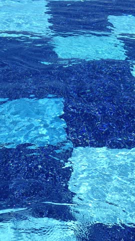 Blue water in the swimming pool with light reflections. Swimming pool top view. 
