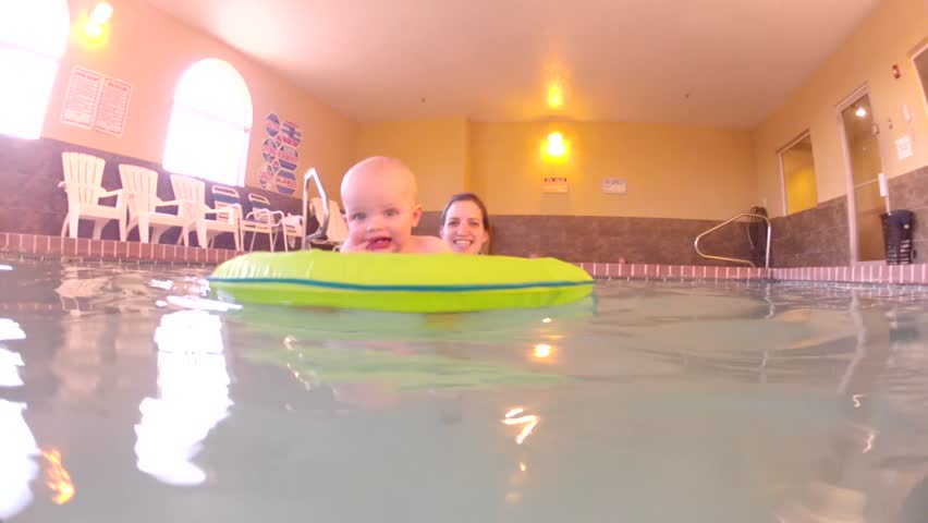 Underwater shot of a cute little baby boy at the swimming pool with his family.