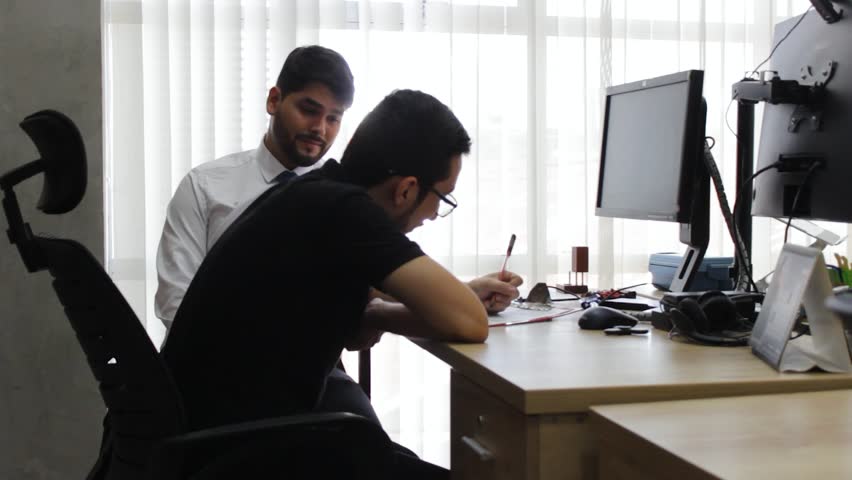 Portrait of two young Colombians executives signing a successful business project with a financial company in a coworking space in Neiva, Huila, Colombia. Concept of work and happiness
