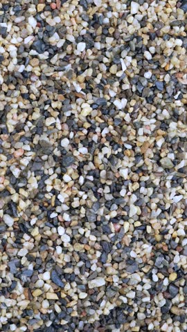 4K close up video of colorful round pebbles, gravel, and sand stones with natural texture. Perfect for backgrounds, design elements, nature concepts, and abstract decorative themes.