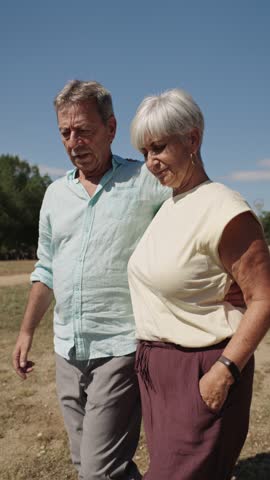 Happy senior couple walking in park, slow motion montage