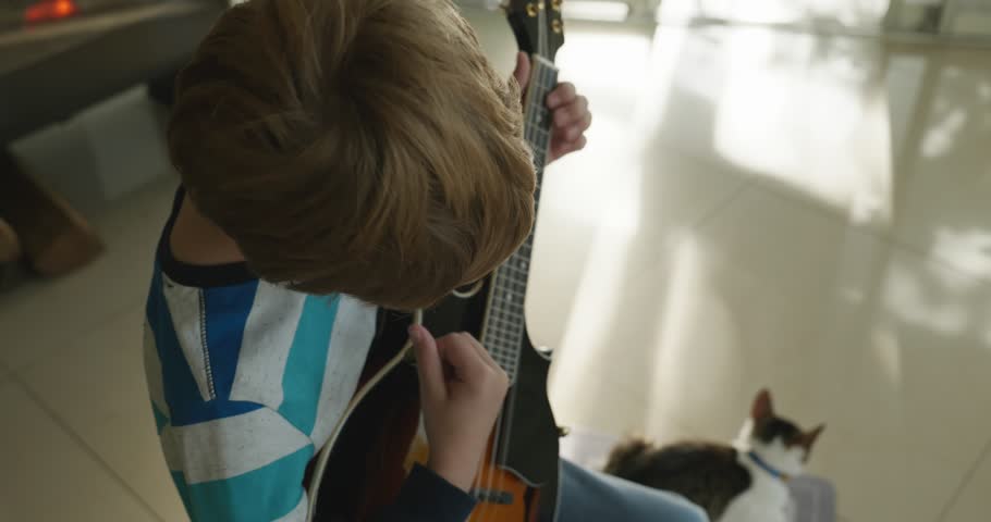 Caucasian Kid Play Mandolin at Home. European Boy Practice Music 4K 10-bit