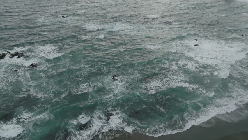 Ocean Waves Crashing on Rocky Shoreline at Sunset