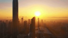 An epic aerial shot captures a modern city skyline at sunrise, with skyscrapers rising through a golden haze as the sun glows on the horizon. - Powered by Shutterstock - Get 15% off with code: PIKWIZARD15