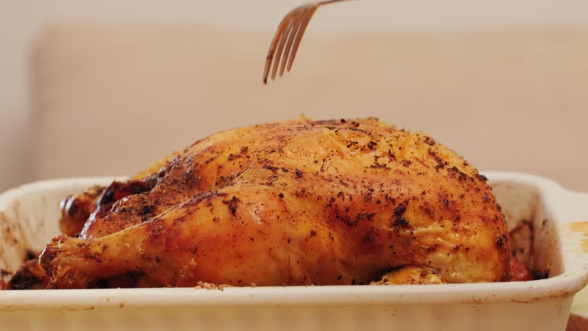 Full roasted grilled chicken meat in a frying pan with potatoes, cooked food, delicious crust, sause pouring. 