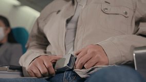 An elderly Asian man wearing a medical face mask sitting on an airplane during travel, showing safety, health protection, and modern transportation lifestyl - Powered by Shutterstock - Get 15% off with code: PIKWIZARD15