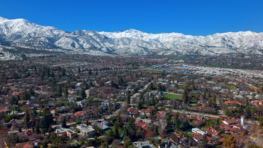 Establishing Aerial fly La Dehesa in Lo Barnechea, Santiago de Chile neighborhood, with Andes Mountain Range Snowy Background