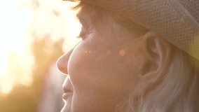 Golden hour sunlight illuminates farmer woman profile wear straw hat. Portrait mature female farmer on ranch. Warm rays of sun at sunset illuminate face with close eyes enjoys warmth and energy of sun - Powered by Shutterstock - Get 15% off with code: PIKWIZARD15