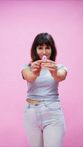 Female putting a pink ribbon on her shirt for breast cancer awareness