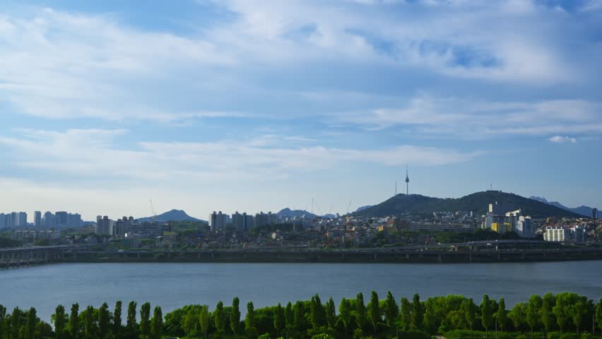Beautiful aerial view of the iconic Seoul cityscape featuring Namsan Tower, the lush Hangang Park, and traffic on the Gangbyeonbuk-ro expressway
