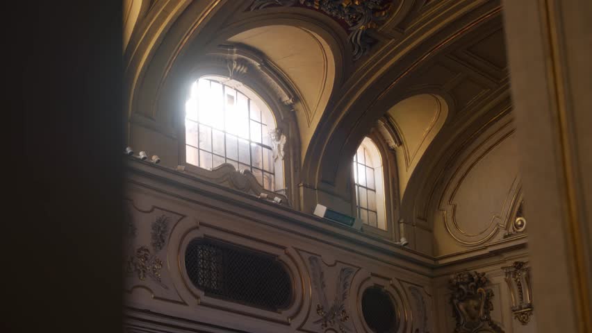 Sun light shining in from beautiful church or cathedral glass windows in Europe. Bright sun beams illuminate the dark large old hall of christian worship place chapel or church. God like rays