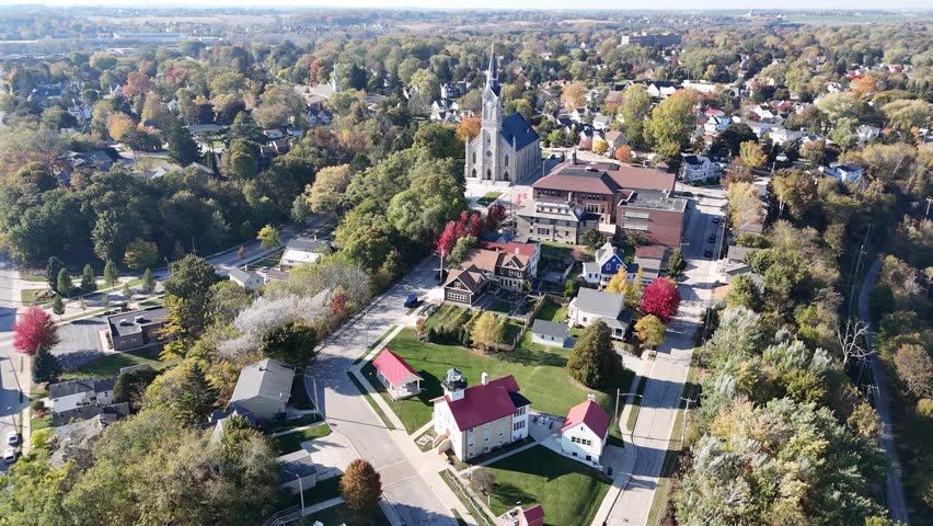 Slow cinematic aerial view of downtown Port Washington WI featuring iconic the beautiful Saint Mary
