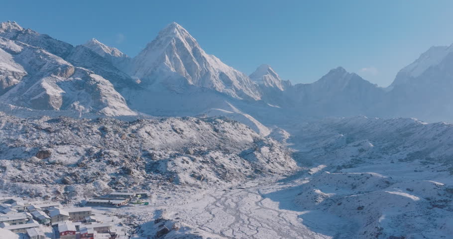 Aerial drone view of Everest Base Camp trek in Khumbu, Nepal. Morning snowfall reveals Lobuche Sherpa village with Himalayan houses beneath Pumori and Lhotse peaks, a peaceful and calming scene