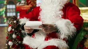 Smiling Santa Claus reading letters from kids, answering them, helping keep belief alive, showing thumbs up sign. Elderly person wearing Christmas costume doing positive agreement gesturing, camera A - Powered by Shutterstock - Get 15% off with code: PIKWIZARD15