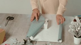 wrapping a Christmas present in craft colored paper - Powered by Shutterstock - Get 15% off with code: PIKWIZARD15