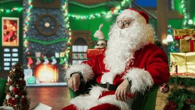 Santa Claus reading kids letters using augmented reality tech after adorning workshop with Christmas ornaments. Santa in holiday season ambiance reading children wish lists on AR hologram, camera A - Powered by Shutterstock - Get 15% off with code: PIKWIZARD15