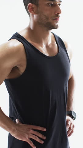 Vertical video: Opening studio shot, Middle Eastern man crossing arms rotating wrists wearing watch. Fitness, masculinity, strength, confidence, posture, discipline, vertical video