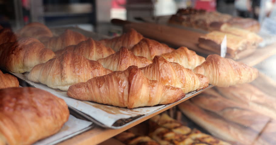 Paris France golden croissant in bakery window of traditional boulangerie showing fresh flaky pastry detail