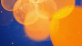 Abstract bokeh background with soft focus glowing orange orbs against a deep blue backdrop. - Powered by Shutterstock - Get 15% off with code: PIKWIZARD15
