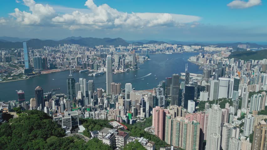 Aerial drone footage capturing Hong Kong harbour with city skyline, bustling vessels, and waterfront views, highlighting maritime transport, urban architecture, and iconic coastal landscapes