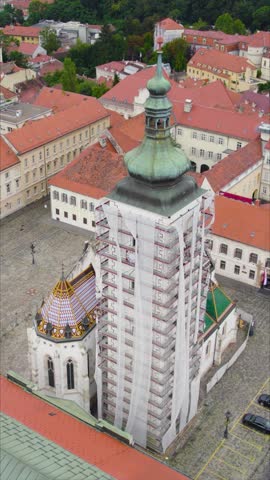 Vertical aerial of iconic St. Mark’s Church in Zagreb, Croatia, showcasing its vibrant tiled roof, historic architecture, and charming old-town surroundings.