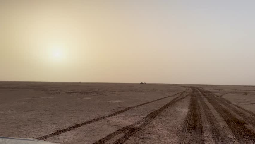 Vast desert landscape with quad and buggy tracks under warm sunset sky symbolizing endurance freedom adventure exploration resilience and the raw beauty of offroad motorsport challenge in wilderness
