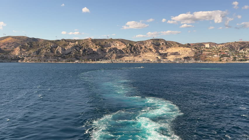 the rear view of a large ship leaving the port of Marseille