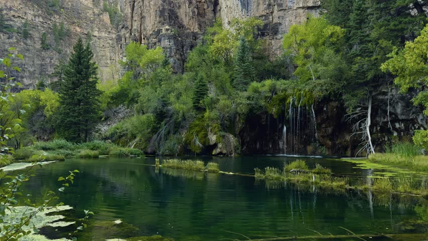 Hanging Lake reflecting forest and cliffs in Glenwood Canyon, Colorado, establishing pan
