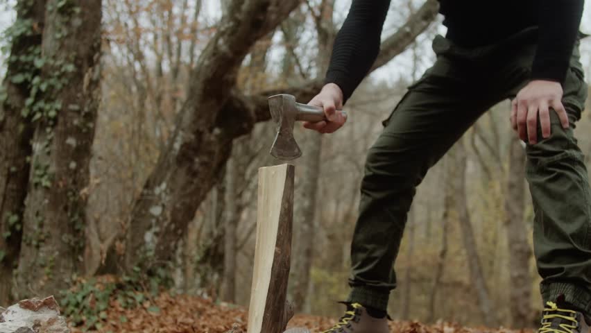 Close-up guy chopping wood. Spreads the shavings. Front view. Slow motion video 4K