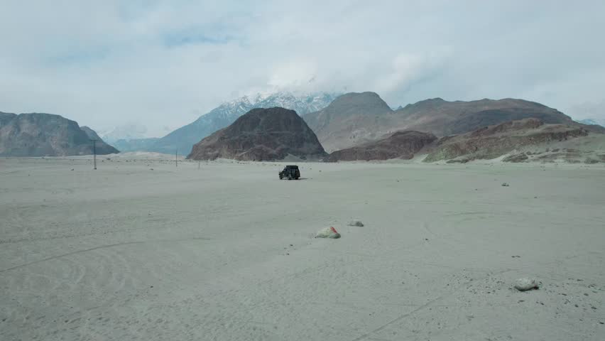 Beautiful drone view of Desert in Gilgit Baltistan, Pakistan. Beautiful mountains, snow capped mountains, mountains jeep, travelling, nature, cloudy weather, sand, beauty, northern ares of Pakistan.
