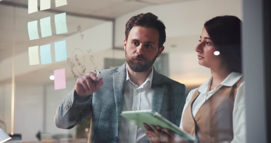 Business team, tablet and writing on glass in office for profit margin, pricing strategy and planning. Financial stakeholders, people and notes with tech for operational efficiency and startup growth
