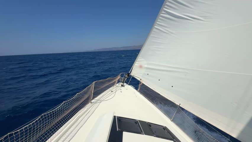 Bow of a sailing yacht cutting through the sea with sails fully open near Croatia. Freedom, motion, clean energy and slow travel on the open water. High quality 4k footage