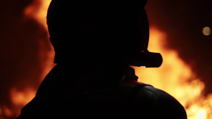 San Juan close-up of a firefighter with a fire in the background