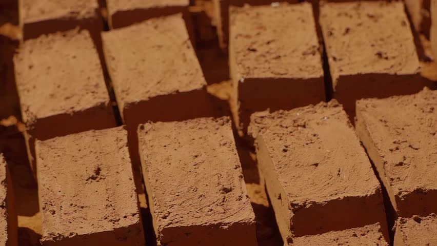 Rows of freshly made adobe bricks are drying under the sun in Chapada dos Veadeiros, Brazil, showcasing a sustainable and traditional building technique