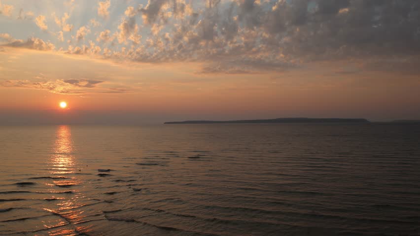 Straits of Mackinac at sunset with Mackinac Island, Michigan in the distance with stable video.