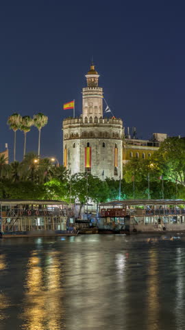 Torre del Oro timelapse hyperlapse, a dodecagonal military watchtower in Seville, Spain. Built by the Almohads to control Guadalquivir River access. Historic landmark with reflections at night.