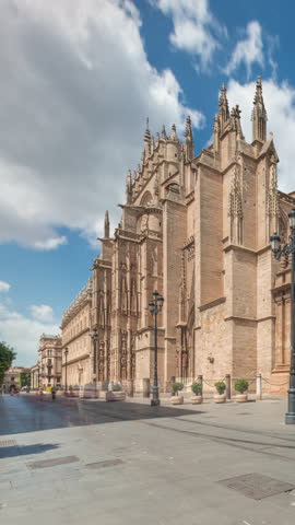 The Seville Cathedral and Giralda Tower timelapse hyperlapse in Seville, Spain. The largest gothic cathedral in the world, UNESCO heritage site, located on Avenue de la Constitucion under a blue sky