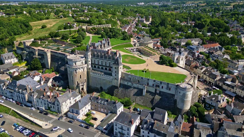 Amboise Royal Chateau viewed from above, historic fortress with turrets and river nearby, panoramic aerial orbit