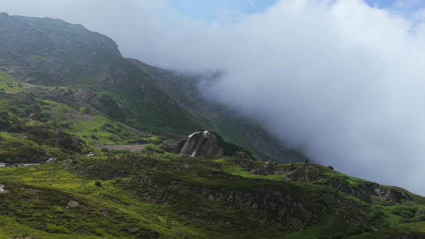 Waterfalls Flowing On The Rocky Cliff With Foggy Mountains In The Background In Susten Pass, Switzerland. - aerial shot