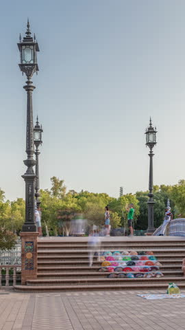 Plaza de Espana in Seville timelapse hyperlapse, a grand architectural complex in Maria Luisa Park built for the Ibero-American Exposition. Bridge with tourists, canal and vintage streetlights