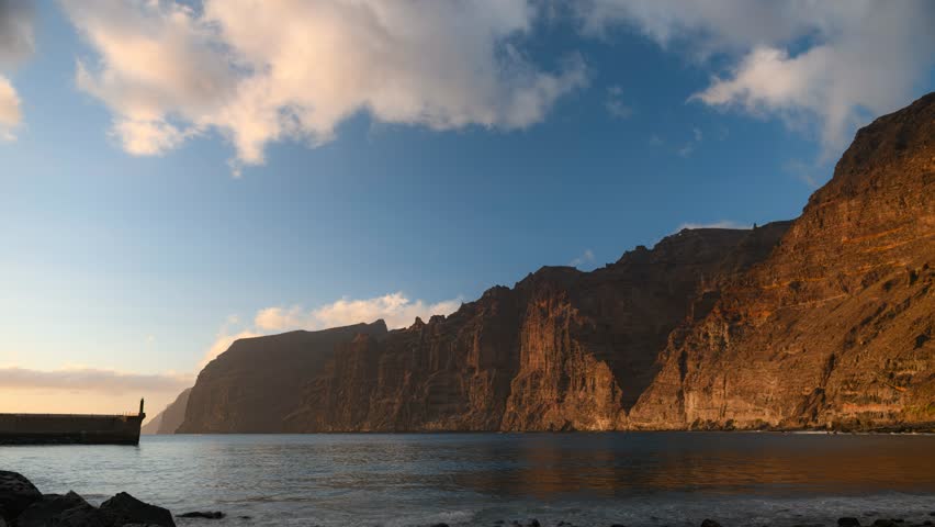 4K timelapse of sunset over Los Gigantes cliffs on Tenerife, Canary Islands. Scenic ocean view, dramatic sky and coastal rocks. Perfect footage for travel, relaxation, tourism and background projects.