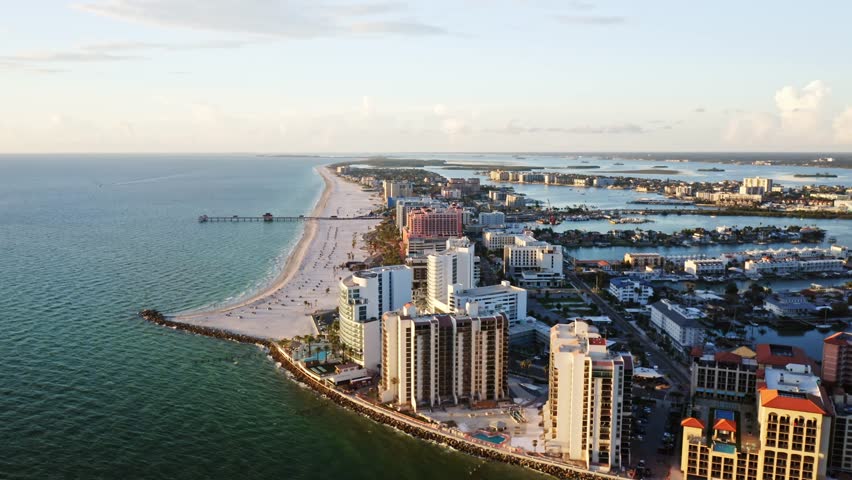 Clearwater Beach’s white sand shoreline stretches toward the pier, lined with resorts and framed by the Gulf of Mexico on one side and inland waterways on the other.