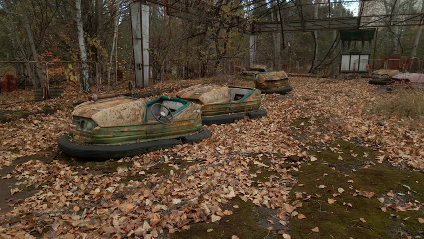 Decayed Autodrome with bumper cars in ghost town Pripyat in radioactive chernobyl exclusion zone. Drone flies at low altitude, 4k aerial video
