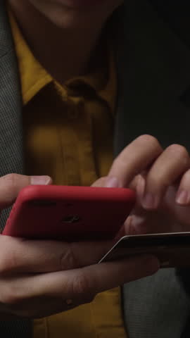 Vertical video. Online shopping, money transfer. Woman pays online using her mobile phone and credit card.