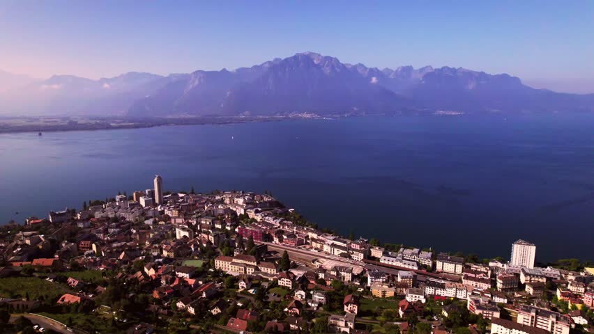 High mountains of French Alps in the background of Montreux at Lake Geneva in Switzerland seen from above on a sunny hazy day and below the a9 freeway in the foreground