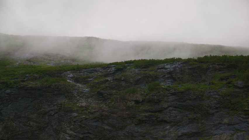 Fog moves slowly over the mountainside in Norway