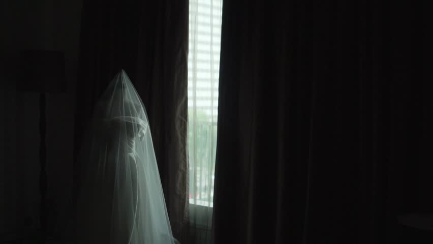 The wedding dress lying near the hotel room window seemed to be waiting for the bride and groom